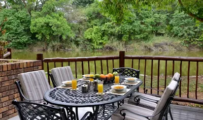 a table with a bowl of fruit sitting on a deck at Cambalala - Luxury Units - in Kruger Park Lodge - Serviced Daily, Free Wi-Fi in Hazyview
