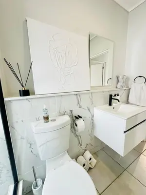 a bathroom with a white toilet and a sink at Lagoon Luxury Stay 2 bed apartment at The Blyde in Pretoria