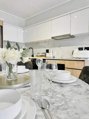 a table with white plates and glasses on it at Lagoon Luxury Stay 2 bed apartment at The Blyde in Pretoria