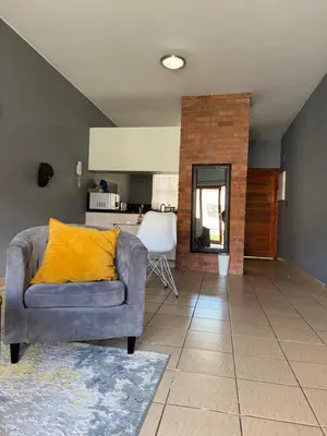 a living room with a couch and a kitchen at 2 bed room apartment in the heart of midrand in Erand