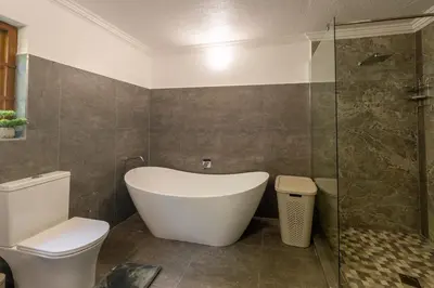 a bathroom with a tub and a toilet and a shower at Kruger Park Lodge Unit No 219 in Hazyview