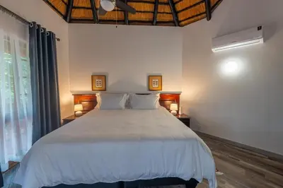 a bedroom with a large white bed with two lamps at Kruger Park Lodge Unit No 219 in Hazyview