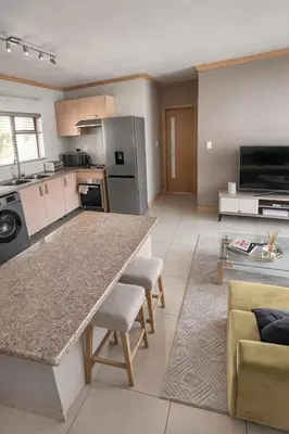 a kitchen with a large island in a living room at Midrand Urban Escape in Midrand