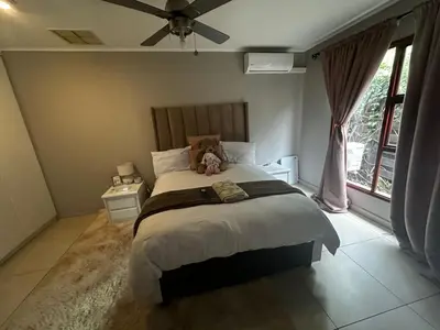 a bedroom with a bed with a teddy bear on it at Kumusha in Hartbeespoort