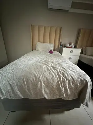 a bedroom with a bed with a white comforter at Kumusha in Hartbeespoort