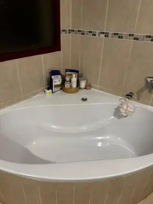 a white bath tub in a bathroom with medicines at Kumusha in Hartbeespoort