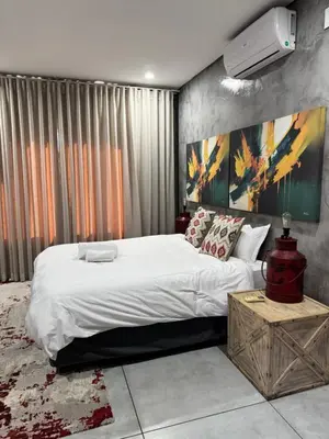 a bedroom with a bed and a painting on the wall at Bras boutique in Steelpoort