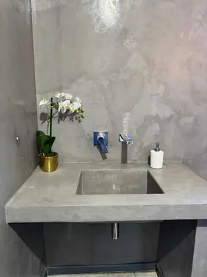 a bathroom sink with a vase of flowers on it at Bras boutique in Steelpoort