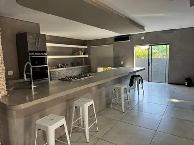 a large kitchen with a counter and stools in it at Bras boutique in Steelpoort