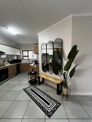 a kitchen with a bench and a mirror on the wall at Elegant Lifestyle Apartment in Waterfall in Midrand