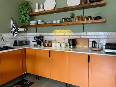 a kitchen with orange cabinets and a counter at Iris HAVEN feel at home in Pretoria