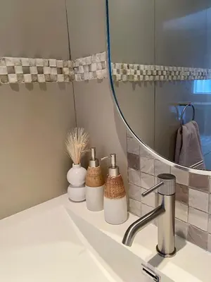 a bathroom sink with a mirror and some vases at Iris HAVEN feel at home in Pretoria