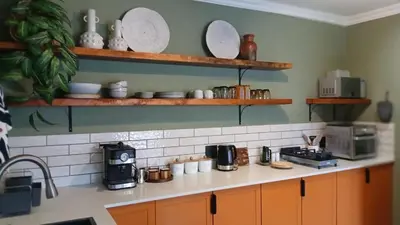 a kitchen with a counter with plates on shelves at Iris HAVEN feel at home in Pretoria