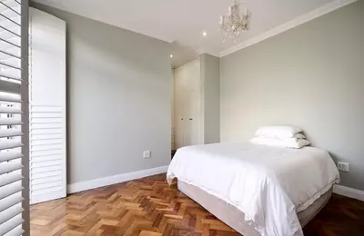 a bedroom with a white bed and a chandelier at The Residence in Midrand
