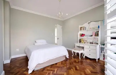 a white bedroom with a bed and a dresser at The Residence in Midrand