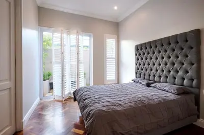 a bedroom with a large bed with a large headboard at The Residence in Midrand
