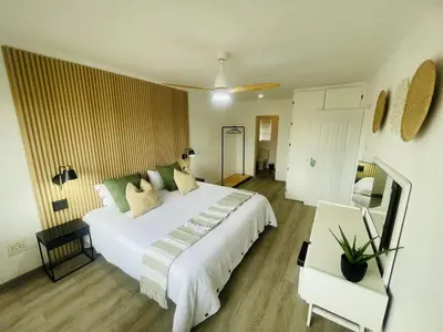 a bedroom with a large white bed and a table at Country Villa in Nelspruit