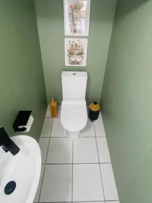 a bathroom with a white toilet and a sink at Country Villa in Nelspruit