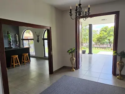 a living room with a door open to aoyer with a table at Namloom Guesthouse in Pretoria