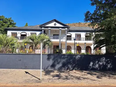 a large white house with a sign in front of it at Namloom Guesthouse in Pretoria