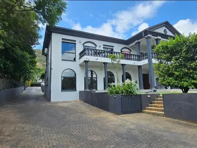 a white house with a balcony on a street at Namloom Guesthouse in Pretoria