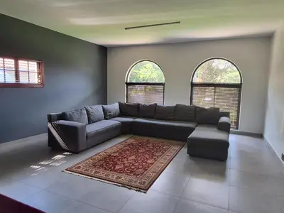 a living room with a couch and two windows at Namloom Guesthouse in Pretoria