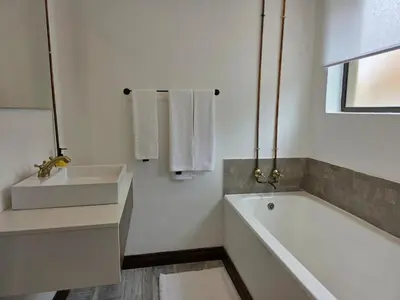 a white bathroom with a sink and a tub and a sink at Stayfit 04 in Polokwane