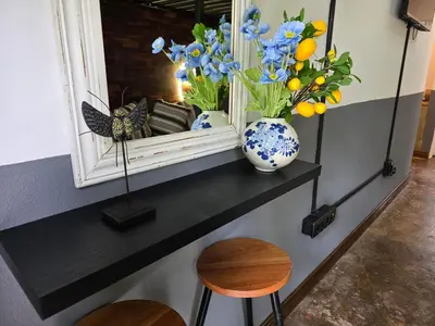 a shelf with a vase of flowers and a mirror at Stayfit 04 in Polokwane
