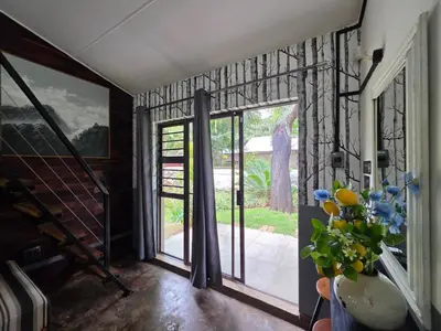a room with a glass door and a vase of flowers at Stayfit 04 in Polokwane