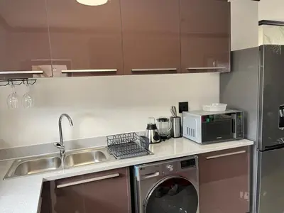 a kitchen with a washing machine and a microwave at Cozy retreat in Bluehills in Midrand