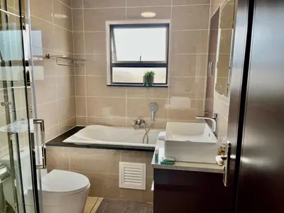 a bathroom with a tub and a toilet and a sink at Cozy retreat in Bluehills in Midrand