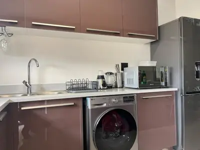 a kitchen with a washing machine in a kitchen at Cozy retreat in Bluehills in Midrand