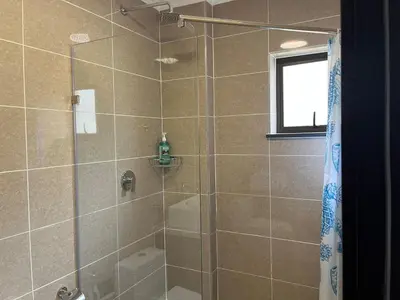 a bathroom with a shower with a glass door at Cozy retreat in Bluehills in Midrand
