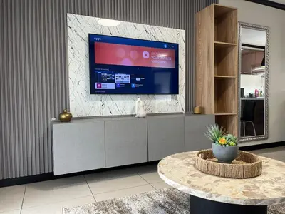 a living room with a large flat screen tv at Cozy retreat in Bluehills in Midrand