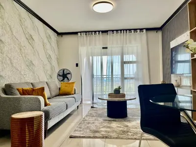 a living room with a couch and a glass table at Cozy retreat in Bluehills in Midrand