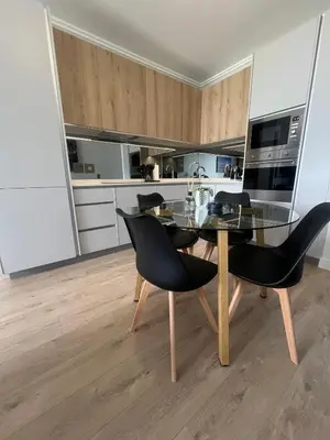 a dining room with a glass table and black chairs at Maboneng at Ellipse Waterfall in Midrand