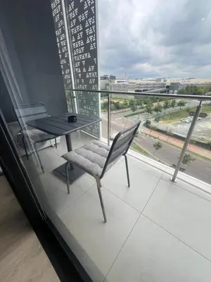 a table and a chair on a balcony with a view at Maboneng at Ellipse Waterfall in Midrand