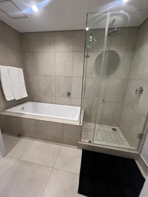 a bathroom with a shower and a bath tub at Maboneng at Ellipse Waterfall in Midrand