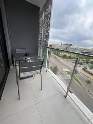 a balcony with a table and a view of a street at Maboneng at Ellipse Waterfall in Midrand