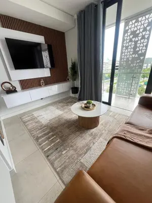 a living room with a couch and a tv at LeeMo at Ellipse Waterfall in Midrand