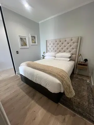 a bedroom with a large bed with white sheets and pillows at LeeMo at Ellipse Waterfall in Midrand