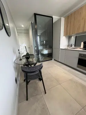 a kitchen with a glass table and a table and a chair at LeeMo at Ellipse Waterfall in Midrand