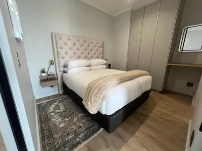 a bedroom with a large bed with white sheets and pillows at LeeMo at Ellipse Waterfall in Midrand
