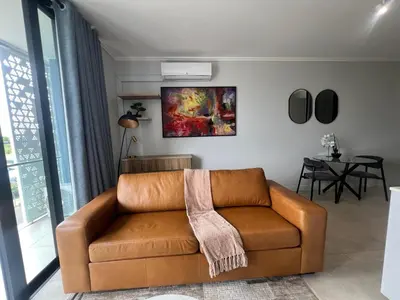 a brown leather couch in a living room at LeeMo at Ellipse Waterfall in Midrand