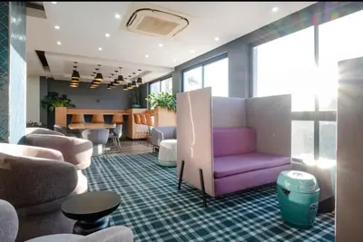 a living room with a purple couch and chairs at Luxurious queen room in Pretoria