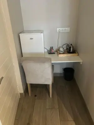 a desk with a chair and a refrigerator in a room at Luxurious queen room in Pretoria