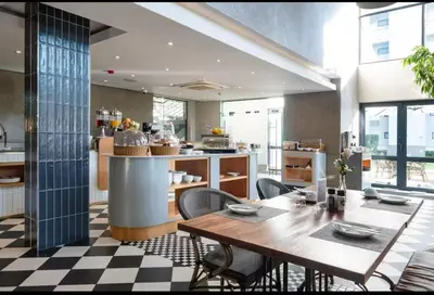 a kitchen with a wooden table and chairs in a room at Luxurious queen room in Pretoria