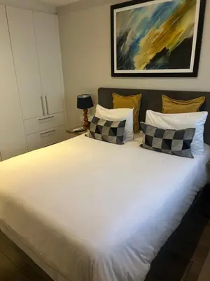 a bedroom with a large white bed with four pillows at Luxurious queen room in Pretoria