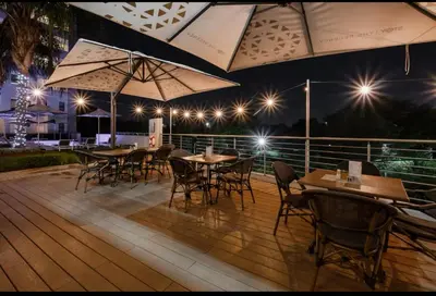 a group of tables and chairs on a deck at night at Luxurious queen room in Pretoria