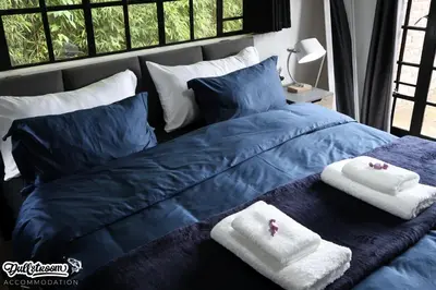 a blue bed with towels on top of it at Kilmister Cottage in Dullstroom